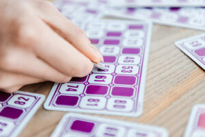 cropped view of woman holding coin and scratching lottery ticket